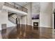 Large living area featuring a stone fireplace, dark wood floors, and an open staircase to the second floor at 4717 Emerald Palms Ct, Winter Haven, FL 33884