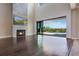 Open living space featuring a stone fireplace, dark wood floors, and a large sliding glass door to the backyard at 4717 Emerald Palms Ct, Winter Haven, FL 33884