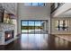 Open living area with a stone fireplace, dark wood floors, and sliding glass doors leading to the backyard at 4717 Emerald Palms Ct, Winter Haven, FL 33884