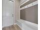 Mudroom area featuring coat hooks, a built-in bench, and a white door at 4717 Emerald Palms Ct, Winter Haven, FL 33884