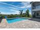 Inviting pool and spa overlooking serene lake views with brick pavers and black aluminum fence at 4717 Emerald Palms Ct, Winter Haven, FL 33884