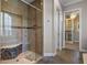 Walk-in shower featuring tan tile, a built-in bench, and a glass door at 4717 Emerald Palms Ct, Winter Haven, FL 33884