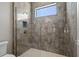 Updated bathroom shower with gray tile, window, and glass enclosure at 4717 Emerald Palms Ct, Winter Haven, FL 33884