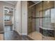 Walk-in shower featuring tan tile, a built-in bench, and a glass door at 4717 Emerald Palms Ct, Winter Haven, FL 33884