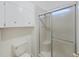 Clean bathroom showcasing a toilet, storage cabinet, and a glass-enclosed shower with a built-in seat at 4986 Foxwood Lake Dr, Lakeland, FL 33810