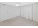 Minimalist bedroom featuring built-in closets, a ceiling fan, and neutral carpeting, with a door to the left at 4986 Foxwood Lake Dr, Lakeland, FL 33810