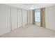 Bright bedroom with sliding closet doors, ceiling fan, plush carpet, and a large window with curtains at 4986 Foxwood Lake Dr, Lakeland, FL 33810