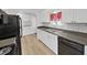 Kitchen with white cabinets, stone countertops, stainless steel sink, and black appliances at 4986 Foxwood Lake Dr, Lakeland, FL 33810