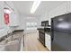 Kitchen with white cabinets, black appliances and stone countertops, leading to a dining room at 4986 Foxwood Lake Dr, Lakeland, FL 33810
