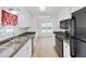 Modern kitchen with stainless steel sink, white cabinets and black appliances leading into dining room at 4986 Foxwood Lake Dr, Lakeland, FL 33810