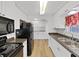 View of eat-in kitchen with modern appliances, white cabinets and neutral plank flooring at 4986 Foxwood Lake Dr, Lakeland, FL 33810