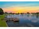 Beautiful sunset over the community pond with a fountain and wooden dock at 4986 Foxwood Lake Dr, Lakeland, FL 33810