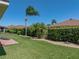Expansive backyard with manicured lawn, privacy hedges, stone accents, and a brick patio area for outdoor enjoyment at 5325 Nicklaus Dr, Winter Haven, FL 33884