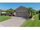 A single-story home with mature landscaping and a brick driveway leading to an attached two-car garage at 5325 Nicklaus Dr, Winter Haven, FL 33884