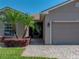 Single-story home featuring mature landscaping and a brick driveway leading to an attached two car garage at 5325 Nicklaus Dr, Winter Haven, FL 33884