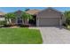 Single-story home with a brick driveway, tropical landscaping and an attached two car garage at 5325 Nicklaus Dr, Winter Haven, FL 33884