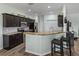 Well-lit eat-in kitchen boasts stainless appliances, breakfast bar, and a view to the hallway at 5325 Nicklaus Dr, Winter Haven, FL 33884