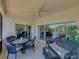 Screened lanai showing view of lawn, with furniture and ceiling fan for comfort at 5325 Nicklaus Dr, Winter Haven, FL 33884
