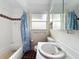 A view of the bathroom featuring a tub, shower, white tiles and window at 5402 Parkway Drive, Belle Isle, FL 32809