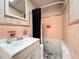 Bathroom with pink tile walls, a white sink and vanity, alongside a dark shower curtain at 5402 Parkway Drive, Belle Isle, FL 32809