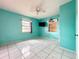 Bedroom with a colorful blue wall paint, ceiling fan, tile floors, and natural light at 5402 Parkway Drive, Belle Isle, FL 32809