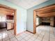 Spacious living area featuring light tile floors with an entrance to the brick fireplace and kitchen at 5402 Parkway Drive, Belle Isle, FL 32809