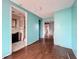 A view of the living room with connected bath featuring hardwood floors and blue walls at 5402 Parkway Drive, Belle Isle, FL 32809