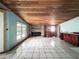 Spacious room featuring a wood ceiling, brick fireplace, and tile floors at 5402 Parkway Drive, Belle Isle, FL 32809