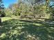 A verdant backyard with a peaceful waterfront view and natural landscaping, perfect for relaxation at 5512 Meander Ln, Lake Wales, FL 33898