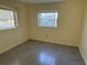 This bedroom features two windows, neutral walls, and concrete floors at 5512 Meander Ln, Lake Wales, FL 33898