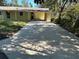 This property features a large concrete driveway and a yellow house at 5512 Meander Ln, Lake Wales, FL 33898