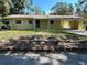 Charming yellow home featuring a covered carport and lovely landscaping at 5512 Meander Ln, Lake Wales, FL 33898