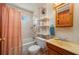 Bathroom with combination tub and shower, wooden vanity and open shelving at 555 Morrel Ave, Lake Wales, FL 33859