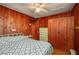 Bedroom with wood walls, vintage dresser, and patterned bedding with ceiling fan at 555 Morrel Ave, Lake Wales, FL 33859