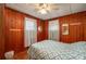 Bedroom features wood paneled walls, two windows with white curtains, and geometric bedding at 555 Morrel Ave, Lake Wales, FL 33859