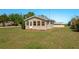 Quaint one-story home with a manicured lawn, tan siding, and welcoming front porch at 555 Morrel Ave, Lake Wales, FL 33859