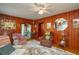 Charming living room featuring wood walls, vintage furniture, and archway to the kitchen at 555 Morrel Ave, Lake Wales, FL 33859