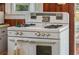 Close up of vintage stove with white enamel finish and retro design details in kitchen at 555 Morrel Ave, Lake Wales, FL 33859