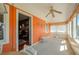 Bright sunroom with an orange wall, white wicker table, and access to the living room at 555 Morrel Ave, Lake Wales, FL 33859