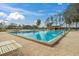 Community swimming pool area featuring lounge chairs and mature trees at 602 Turnberry Ct, Winter Haven, FL 33884