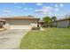 Spacious two-car garage with a well-kept lawn and mature landscaping, adding curb appeal at 602 Turnberry Ct, Winter Haven, FL 33884