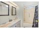 Bathroom featuring double sinks, decorative mirrors, and a shower/tub with shower curtain at 6433 Jacaranda Ne Ave, Winter Haven, FL 33881