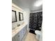 Bathroom featuring double sinks, decorative mirrors, and toilet with black bath mat at 6433 Jacaranda Ne Ave, Winter Haven, FL 33881