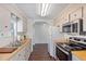 Well-lit kitchen featuring wood counters, white appliances, and a seamless flow to other spaces at 6433 Jacaranda Ne Ave, Winter Haven, FL 33881