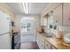 Functional kitchen with white cabinets, stainless steel appliances, and a view into the living area at 6433 Jacaranda Ne Ave, Winter Haven, FL 33881