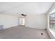 Bright living room featuring neutral carpet, ceiling fan, sliding glass door, and picture window at 6433 Jacaranda Ne Ave, Winter Haven, FL 33881