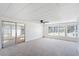 Bright living room featuring neutral carpet, ceiling fan, and large windows for plenty of natural light at 6433 Jacaranda Ne Ave, Winter Haven, FL 33881