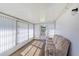 Bright sunroom featuring large windows with white vertical blinds and comfortable seating at 6433 Jacaranda Ne Ave, Winter Haven, FL 33881