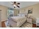 Sunny bedroom with a queen bed, ceiling fan, and a bright window, decorated with 'Florida' themed decor at 67 Alachua Dr, Winter Haven, FL 33884