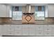 Well-lit kitchen featuring granite countertops, tile backsplash, stainless steel hood, and ample cabinet space at 67 Alachua Dr, Winter Haven, FL 33884